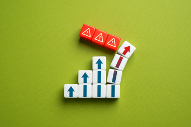 Dice representing four upward-pointing arrows and three ‘caution danger’ signs